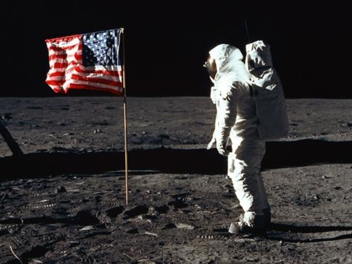 Armstrong on the moon next to American flag